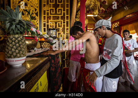 Phuket, Thailand. 3rd Oct, 2016. A devotee from the Chinese Kuan Tae Kun Shrine works himself out of a trance at the end of the ceremony after being possessed by the spirit of god during the yearly Vegetarian Festival, also knows as Nine Emperor Gods Festival in Phuket on October 03, 2016. The Vegetarian Festival described as a colorful event, is held during the ninth lunar month of the Chinese calendar, and celebrate by the Chinese community of Phuket, where the devotees belief that abstinence from all kind of meat will help them obtain good health along their life. (Credit Image: Stock Photo
