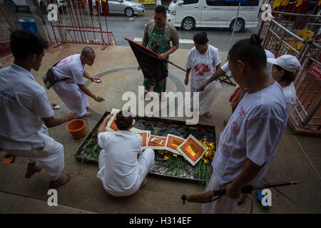 Phuket, Thailand. 3rd Oct, 2016. Devotees from the Chinese Sam Ong Hoo Shrine burn papers during a ceremony ahead of a street procession during the yearly Vegetarian Festival, also knows as Nine Emperor Gods Festival in Phuket on October 03, 2016. The Vegetarian Festival described as a colorful event, is held during the ninth lunar month of the Chinese calendar, and celebrate by the Chinese community of Phuket, where the devotees belief that abstinence from all kind of meat will help them obtain good health along their life. Credit:  Guillaume Payen/ZUMA Wire/Alamy Live News Stock Photo