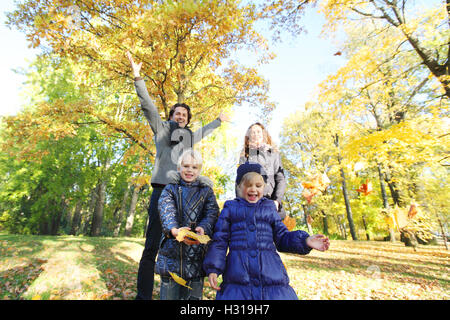 Happy family playing with autumn maple leaves in park Stock Photo - Alamy