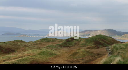 Distant view of Isle of Easdale, Inch Island and Ellenabeich on Isle of Seil from Isle of Luing Scotland  June 2013 Stock Photo