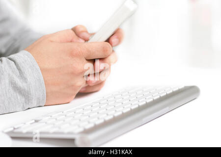 Man using remote while working on desktop Stock Photo