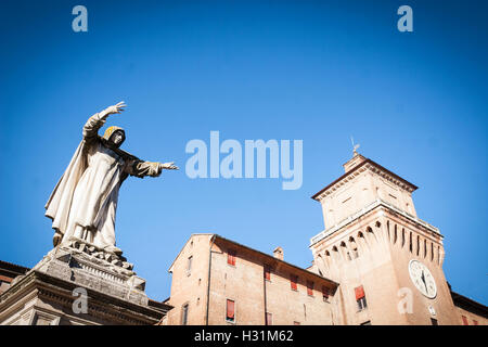 View of Castle Estense or Castle of St Michael from Piazza Savonarola, with statue of monk in foreground, Ferrara Stock Photo