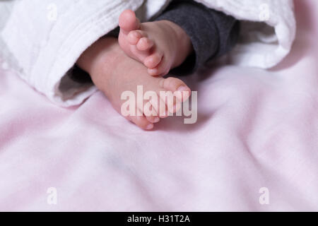 Close up of baby feet sticking out from blanket Stock Photo