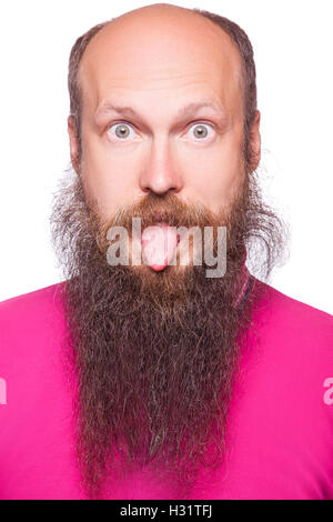 Portrait of a funny young bald, bearded man showing tongue, face expression Stock Photo