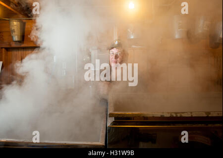 Man checking maple syrup evaporator in Gorham, Maine. Stock Photo