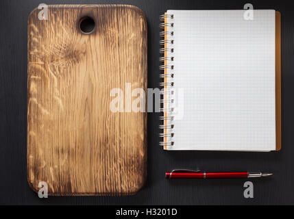 cutting board at wooden table surface Stock Photo
