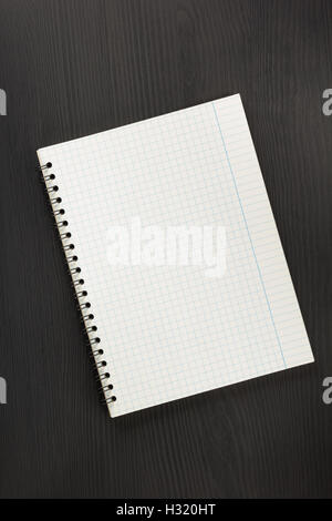 checked notebook on black wooden background Stock Photo