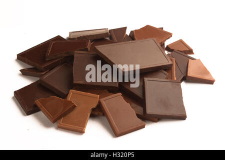 Broken different chocolate bars in many colors and flavors isolated on white background Stock Photo