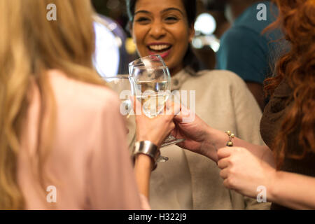 Three women toasting their glasses in a bar Stock Photo
