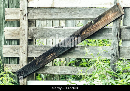 In summer day boarded up old gray wooden fence Stock Photo