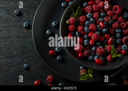 black plate with healthy berries on a dark background Stock Photo