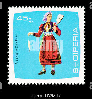 Postage stamp from Albania depicting a woman spinner, Dardhes, in local clothes. Stock Photo