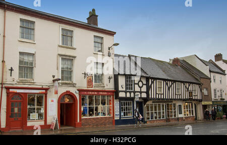 Street in English town of Ashbourne with historic buildings including shops and cafes with people walking on footpath Stock Photo