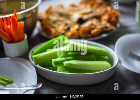 Cut cucumber pieces and carrots in a porcelain plates on a table Stock Photo