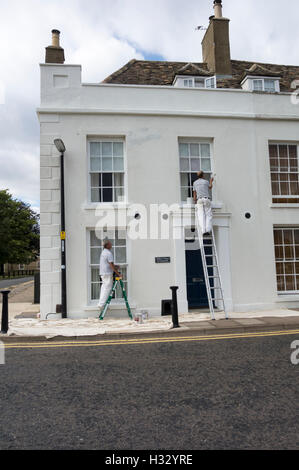 Two painters repainting Millers House Ely city Cambridgeshire England Stock Photo