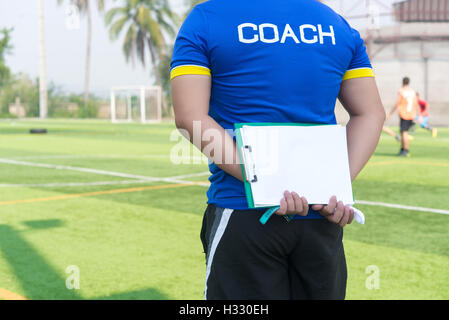 Coach is coaching Children Training In Soccer Team Stock Photo