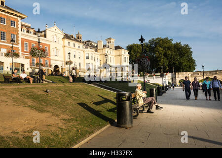 An elderly man sitting in front of exclusive riverside residential property overlooking the River Thames at Richmond Upon Thames, London, England Stock Photo