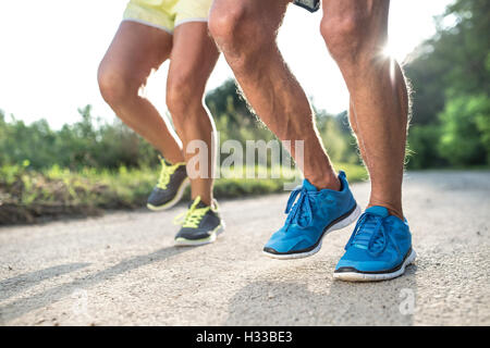 Unrecognizable senior couple running outside in sunny nature Stock Photo
