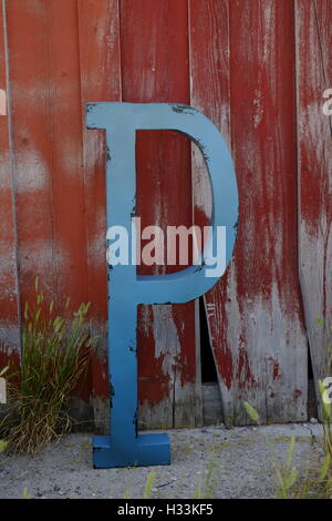 Blue Letter P on Old red barn wood wall Stock Photo