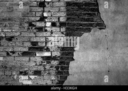 Gray bricks on plastered wall that is falling apart Stock Photo