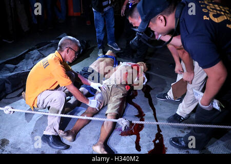 Philippines. 04th Oct, 2016. (EDITOR'S NOTE: Image contains graphic content) Members of S.O.C.O. (Scene of the Crime Operatives) process the crime scene and the remain of two un-identified allegedly drug dealers are the victims of summary executions at the front of Santa Catalina Colleges, Legarda, Manila City. Credit:  Gregorio B. Dantes Jr./Pacific Press/Alamy Live News Stock Photo