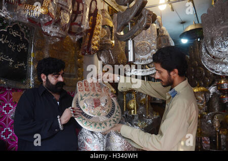 Lahore, Pakistan. 03rd Oct, 2016. Pakistani Shiite Muslims are busy in purchasing related stuff from a vendor as part of the Holy month of Muharram ul Haram. Muharram is known as the first month of the Islamic calendar'Muharram is the mourning month in remembrance of the Shahadat of Shiites'spiritual leader Imam Hussain the grandson of the Holy Prophet Mohammad. © Rana Sajid Hussain/Pacific Press/Alamy Live News Stock Photo