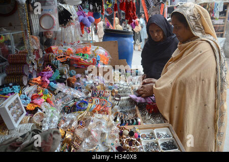 Lahore, Pakistan. 03rd Oct, 2016. Pakistani Shiite Muslims are busy in purchasing related stuff from a vendor as part of the Holy month of Muharram ul Haram. Muharram is known as the first month of the Islamic calendar'Muharram is the mourning month in remembrance of the Shahadat of Shiites'spiritual leader Imam Hussain the grandson of the Holy Prophet Mohammad. © Rana Sajid Hussain/Pacific Press/Alamy Live News Stock Photo