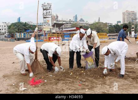 Dabbawalas clean the Chowpatty beach in Mumbai, India on September 16, 2016, and remove the leftover Stock Photo