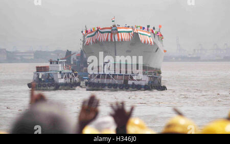 Dock workers wave as Mormugao stealth destroyer rolls into sea during its launch in Mumbai, India on September 17, 2016 Stock Photo