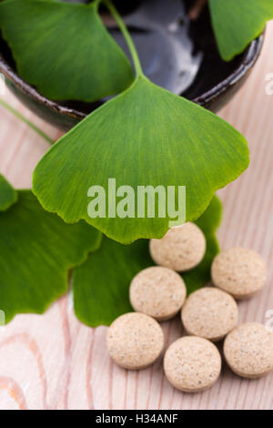 Ginkgo biloba leaves in mortar and pills Stock Photo