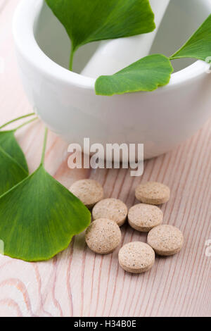 Ginkgo biloba leaves in mortar and pills Stock Photo