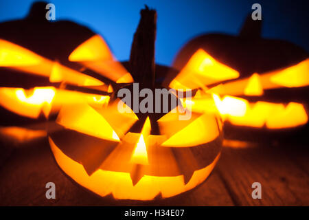 three jack-o-lantern pumpkins glowing in the dark Stock Photo