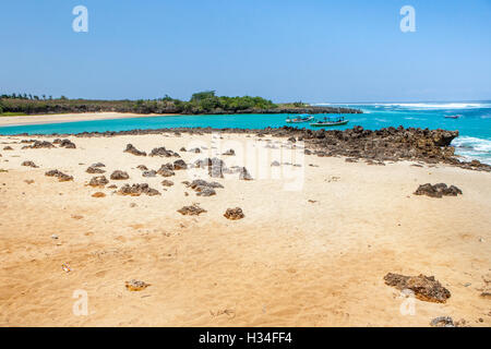 Rocky, sandy tropical beach with wooden boats on the sea are photographed in Pero, Pero Batang, Kodi, Southwest Sumba, East Nusa Tenggara, Indonesia. Stock Photo