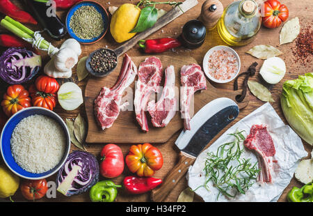 Raw uncooked lamb meat chops, rice, oil, spices and vegetables Stock Photo