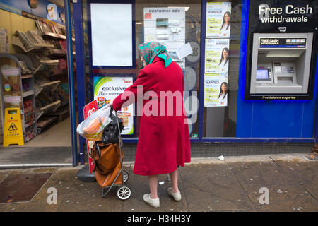 Elderly woman outside newsagent in country town, United Kingdom Stock Photo