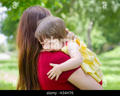 Mother holding crying baby girl with tears Stock Photo