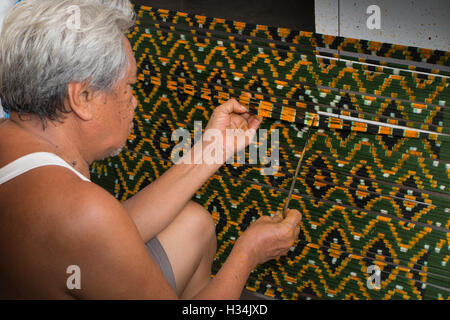 Indonesia, Bali, Singaraja, Pertenunan Berdikari weaving workshop, worker hand dying ikat weft thread pattern Stock Photo