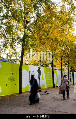 PPE illustration Health and Safety signage hoardings, & fencing around construction and infrastructure site,  part of Piccadilly Gardens as a substantial programme of repair to the water feature, Manchester, UK Stock Photo