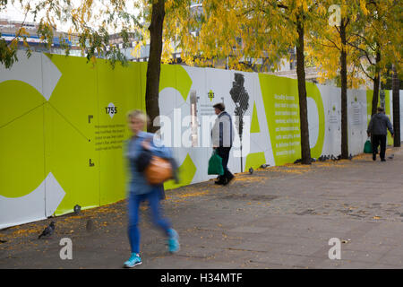 PPE illustration Health and Safety signage hoardings, & fencing around construction and infrastructure site,  part of Piccadilly Gardens as a substantial programme of repair to the water feature, Manchester, UK Stock Photo