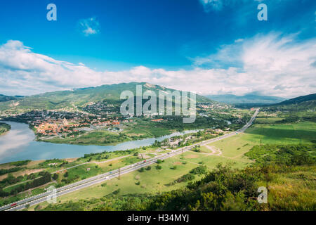 Mtskheta Georgia. Aerial View Of Green Valley And Kura Mtkvari River Surrounded By Picturesque Mountains Under Blue Spring Sky. Stock Photo