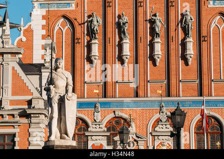 Statue Of Roland At The Town Hall Square On The Background Of The House Of Blackheads In Riga, Latvia. Sunny Summer Day With Blu Stock Photo