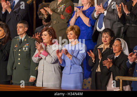 WASHINGTON, DC, USA - First Lady Laura Bush, center, listens to her husband President George W. Bush delivering his State of the Union speech before Congress on February 2, 2005. On either side of Mrs. Bush are two women from Afghanistan and Iraq who voted in their countries' democratic elections. Stock Photo