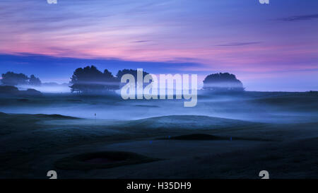 Spring mist lies in the cold undulating valleys across the greens and fairways at Delamere Forest Golf Club, Cheshire, UK Stock Photo