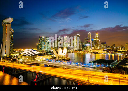 Busy roads leading to the Marina Bay Sands, Gardens by the Bay and ArtScience Museum at dusk with the skyline beyond, Singapore Stock Photo