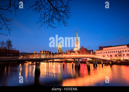The lights of dusk on typical bridge and the cathedral reflected in River Trave, Lubeck, Schleswig Holstein, Germany