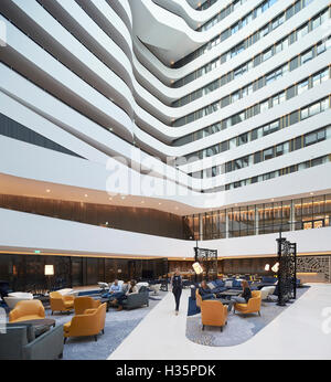 Lounge and reception in full-height atrium. Hilton Amsterdam Airport Schiphol, Amsterdam, Netherlands. Architect: Mecanoo Architects, 2015. Stock Photo