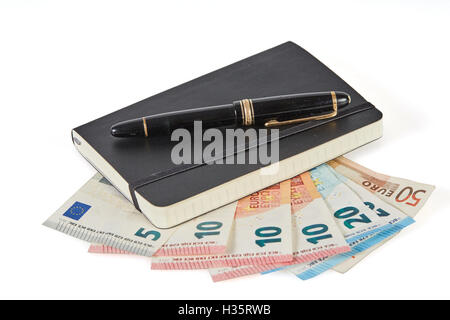 Earning money with writing symbolized with pen and notebook on euro money banknotes Stock Photo
