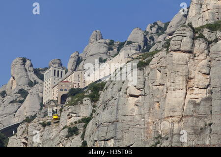 Santa Maria de Montserrat abbey in the top of the mountain, with the yellow aerial cable car Stock Photo