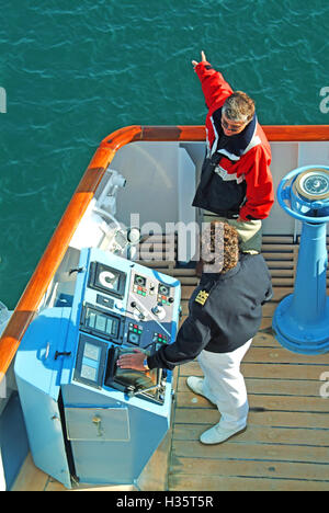 France Port of Sete French local expert pilot working with ship captain at controls wing bridge deck of cruise ship liner during docking manoeuvres Stock Photo