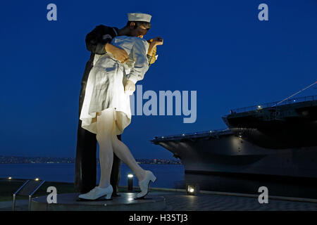 'Unconditional Surrender' sculpture, by Seward Johnson, and USS Midway aircraft carrier, San Diego, California USA Stock Photo